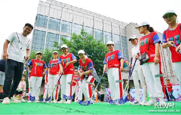 广场舞队成员在轻松愉悦的气氛下学习打陆地冰球