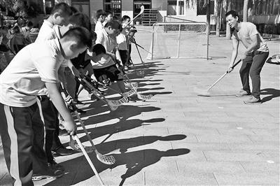 同学们在教练的指导下摆动球杆进行拨球练习