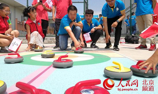 “海坨之星”地壶球队的小队员们,和冬奥工程一线建设者们一起打了一场充满欢声笑语的友谊地壶球赛。